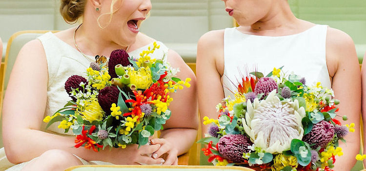 Delighted bride and bridesmaid with stunning colourful flowers